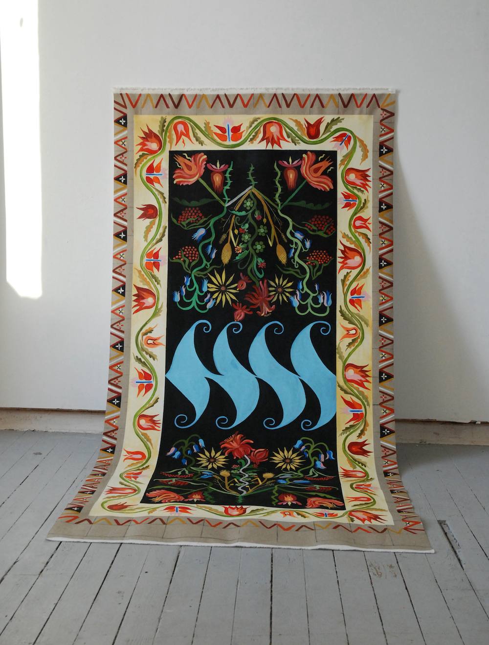 An installation with paintings, textiles and ladders is shown as a physical collage. The space they sit within is white and lit from above.