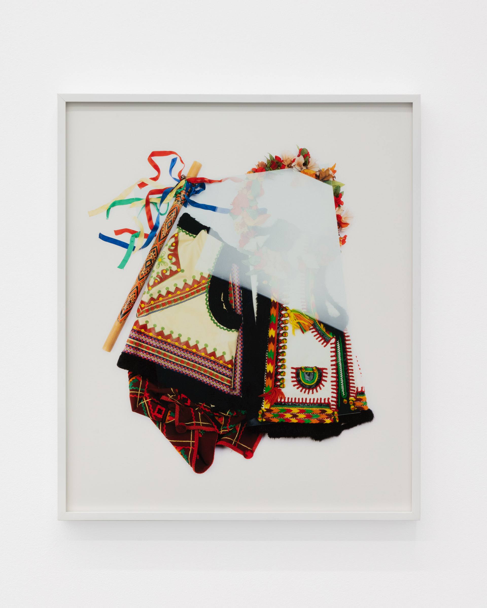 A Carpathian region Ukrainian dance costume is compressed beneath a sheet of glass.